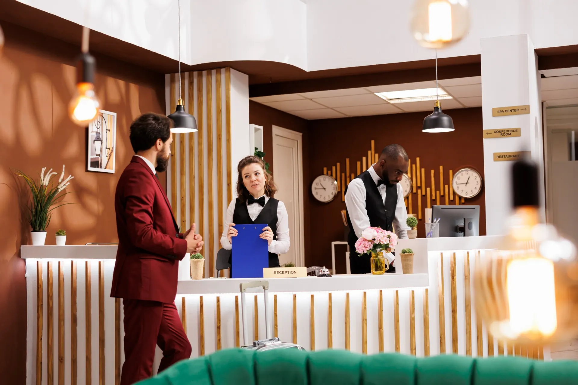 Obsługa hotelowa witająca gościa przy recepcji