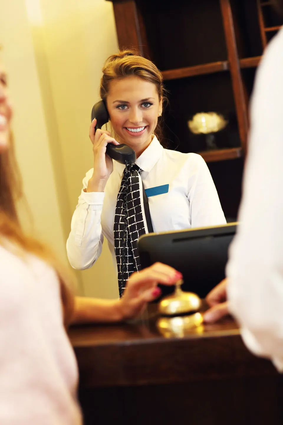 Recepcjonistka hotelowa prowadząca rozmowę telefoniczną z gościem